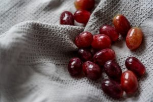 Algumas uvas frescas soltas do cacho jogadas sobre um pedaço de pano